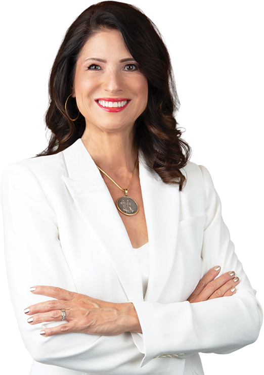 Adriana Guzmán Fralick smiling with her arms crossed in front of a Nevada landscape